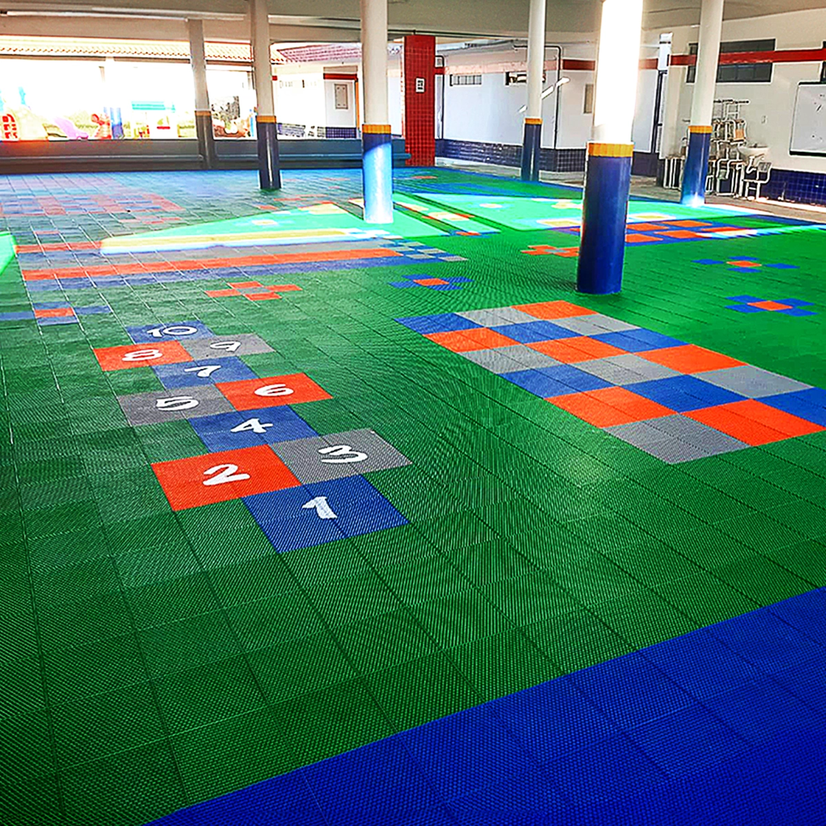 Área recreativa escolar com piso modular outdoor e marcações lúdicas